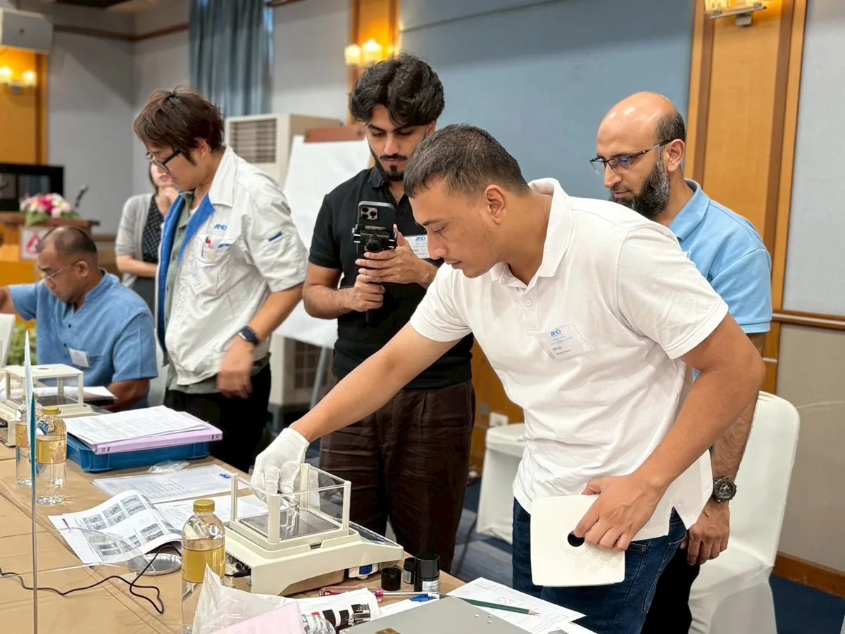 An A&D Gulf engineer operating an analytical balance under A&D Japan instruction during the Thailand service training